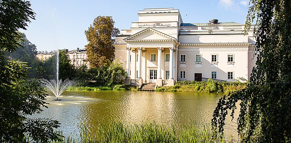 widok na teatr od strony parku miejskiego, na pierwszym planie rzeka Prosna