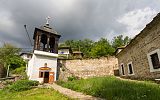 na zdjęciu mały kościół, po prawej stronie kamienne mury