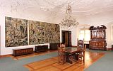 Muzeum Prowincji Ptuj Ormoz - widok wnętrza: trzy arrasy na ścianie, ozdobny strop, stół i krzesła na środku