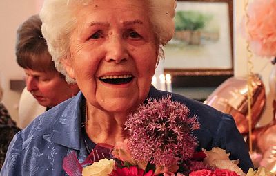 starsza kobieta trzyma bukiet kwiatów